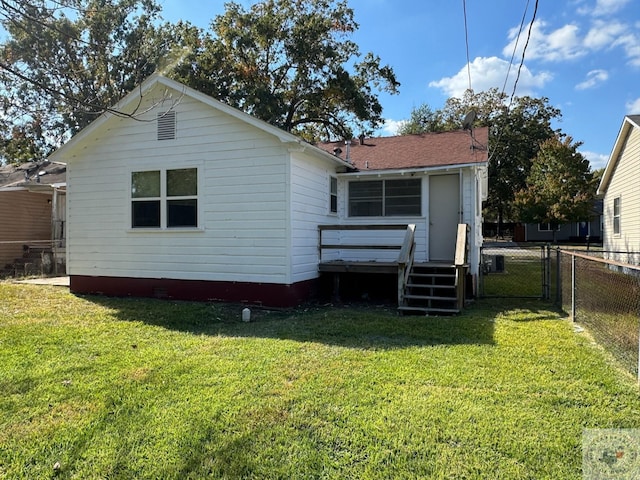 rear view of house featuring a yard