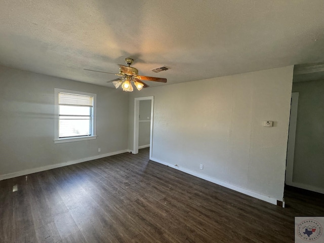 spare room featuring dark wood-type flooring, a textured ceiling, and ceiling fan