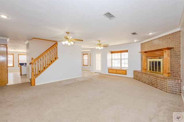 unfurnished living room featuring a fireplace, crown molding, light carpet, and a healthy amount of sunlight