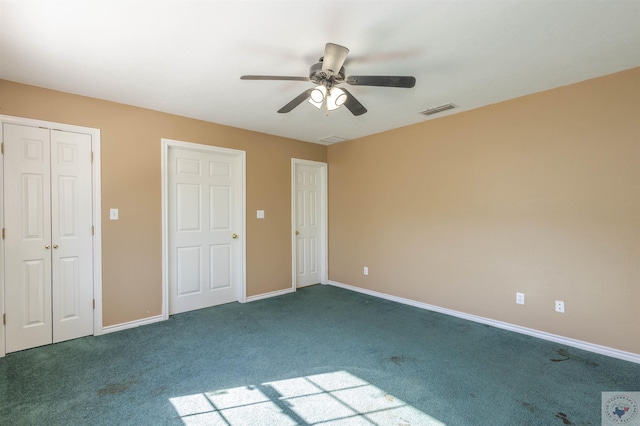 unfurnished bedroom featuring a closet, dark carpet, and ceiling fan