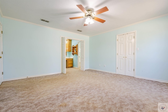 unfurnished bedroom featuring ornamental molding, light colored carpet, ceiling fan, and a closet