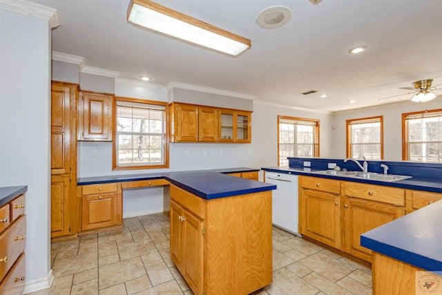 kitchen with built in desk, dishwasher, a kitchen island, sink, and a healthy amount of sunlight