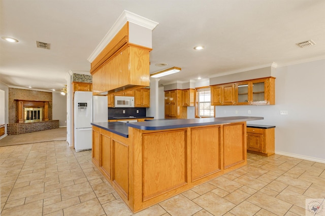 kitchen featuring white appliances, ceiling fan, crown molding, a center island, and a fireplace