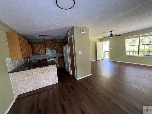 kitchen with white appliances, decorative backsplash, sink, dark hardwood / wood-style floors, and ceiling fan