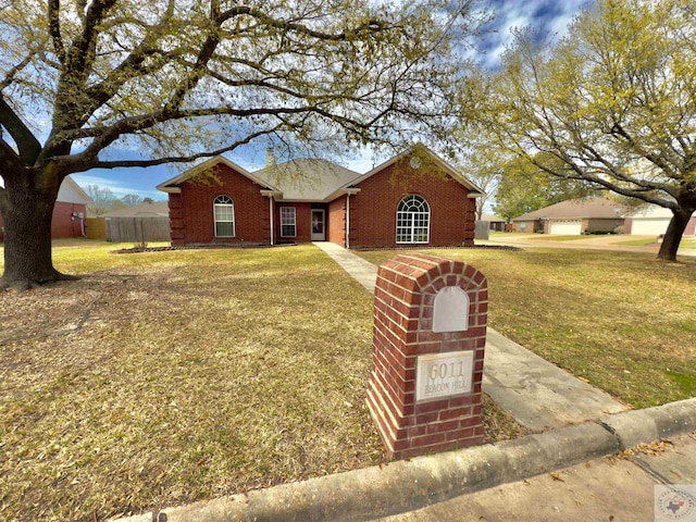 single story home with a front yard, fence, and brick siding