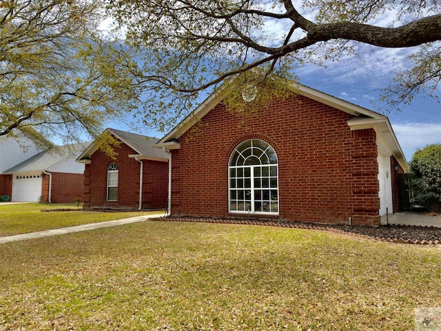 single story home with brick siding, a garage, and a front lawn