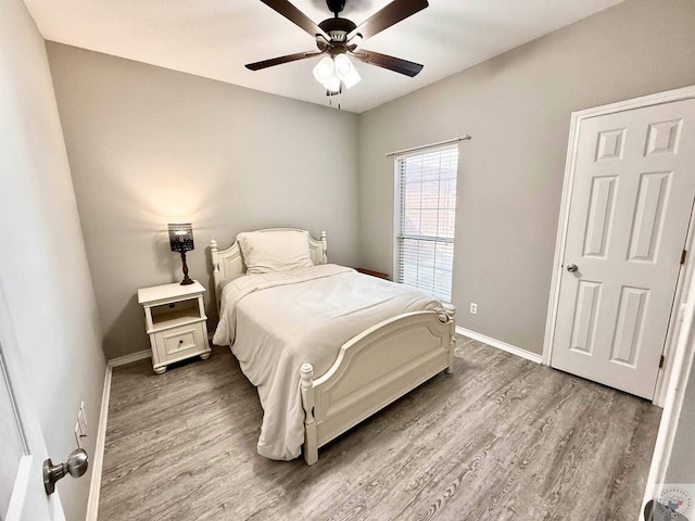 bedroom with baseboards, wood finished floors, and a ceiling fan