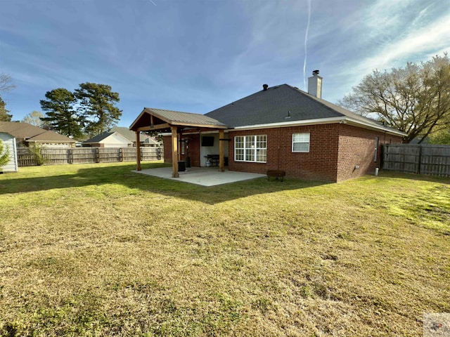back of property featuring a patio, brick siding, a fenced backyard, and a lawn