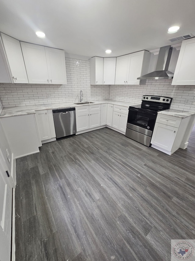 kitchen featuring sink, white cabinetry, wall chimney range hood, and appliances with stainless steel finishes