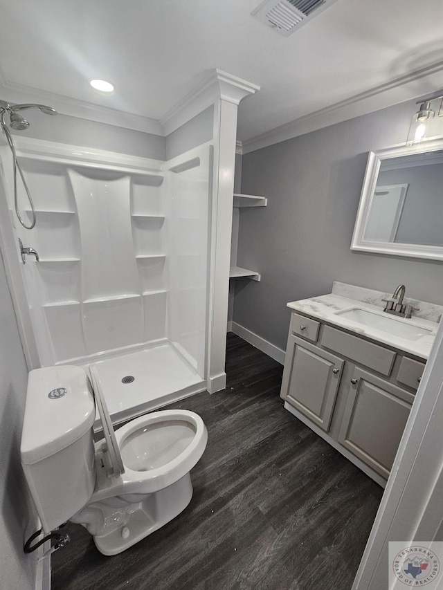 bathroom featuring hardwood / wood-style floors, vanity, toilet, walk in shower, and ornamental molding