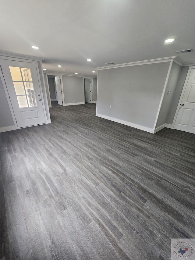 unfurnished living room featuring crown molding and dark wood-type flooring