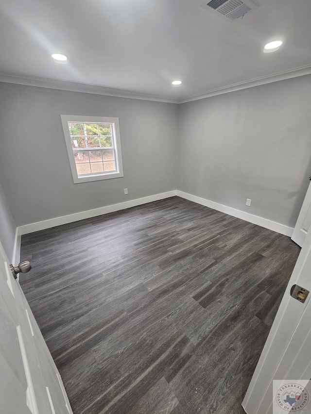 spare room featuring crown molding and dark wood-type flooring