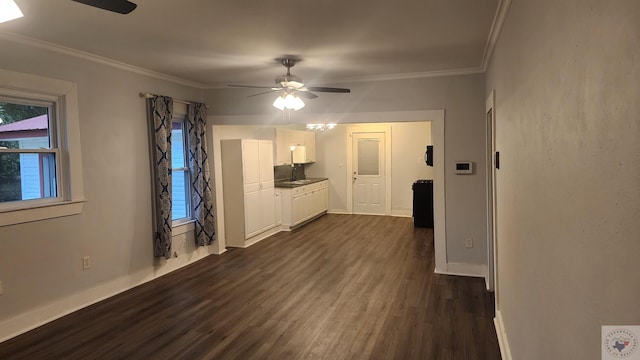 unfurnished living room with sink, ceiling fan, ornamental molding, and dark wood-type flooring