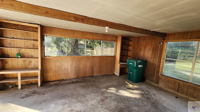 unfurnished sunroom featuring beamed ceiling