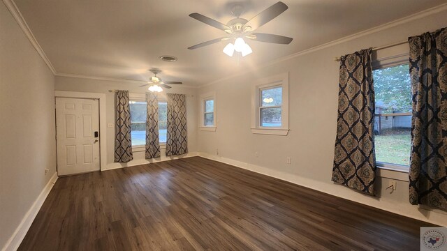 empty room with ornamental molding, plenty of natural light, and dark hardwood / wood-style flooring