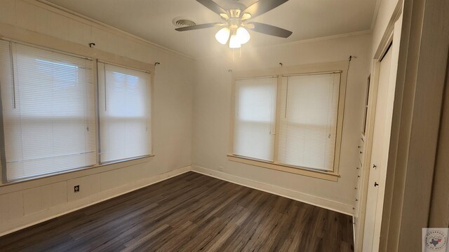 unfurnished room featuring ceiling fan, dark hardwood / wood-style flooring, and ornamental molding