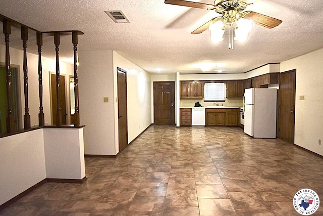 1104A E 23rd St, Texarkana, AR 71854 - kitchen with white appliances, dark brown cabinetry, light countertops, a textured ceiling, and a ceiling fan