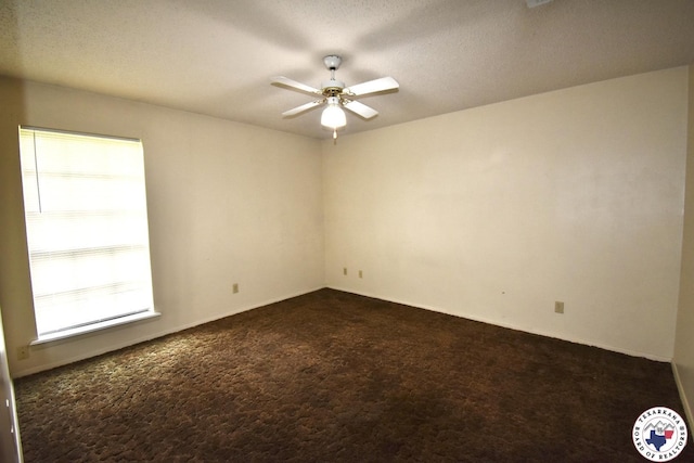 1104A E 23rd St, Texarkana, AR 71854 - spare room featuring dark colored carpet, a ceiling fan, and healthy amount of natural light