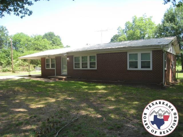 8820 W New Boston Rd, Texarkana, TX 75501 - single story home with brick siding, a front lawn, and metal roof