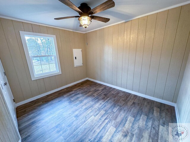 empty room featuring crown molding, electric panel, ceiling fan, and dark hardwood / wood-style flooring