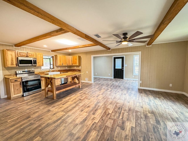 kitchen with ceiling fan, beamed ceiling, hardwood / wood-style floors, stainless steel appliances, and light brown cabinets