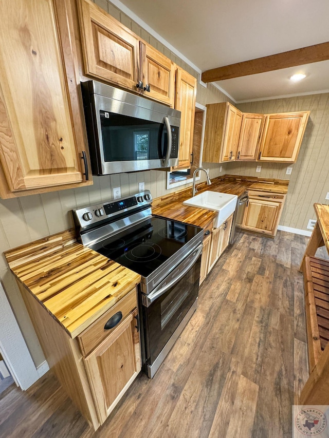 kitchen featuring dark wood-type flooring, stainless steel appliances, sink, butcher block countertops, and beam ceiling