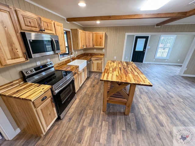 kitchen featuring sink, stainless steel appliances, beamed ceiling, and wooden counters