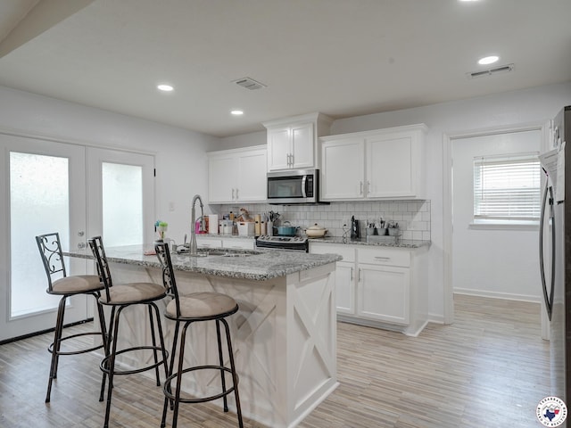 43 Broadmoor Dr, Texarkana, AR 78154 - kitchen with appliances with stainless steel finishes, light wood-type flooring, tasteful backsplash, light stone counters, and recessed lighting