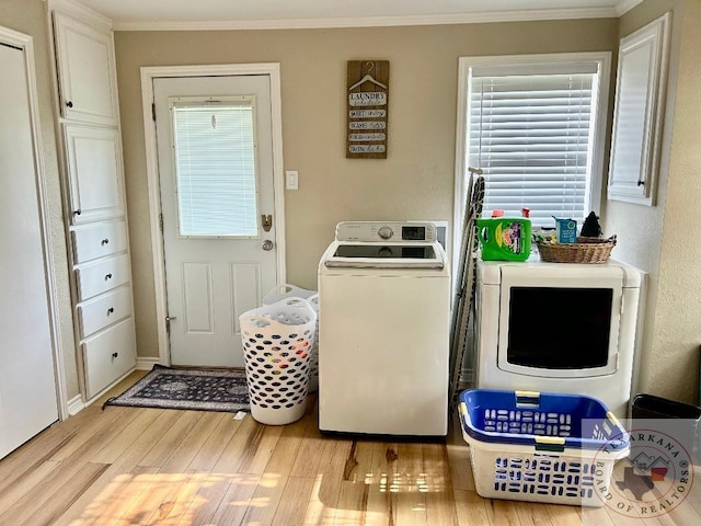 clothes washing area featuring light hardwood / wood-style floors, ornamental molding, and washing machine and clothes dryer