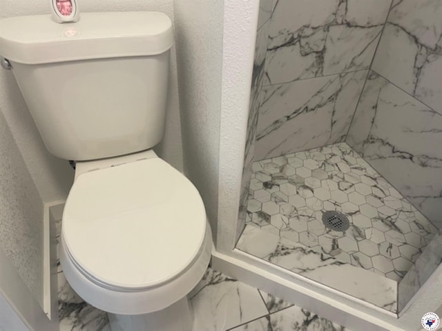 104 Pecan St, Atlanta, TX 75551 - bathroom with a shower stall, toilet, marble look tile flooring, and a textured wall