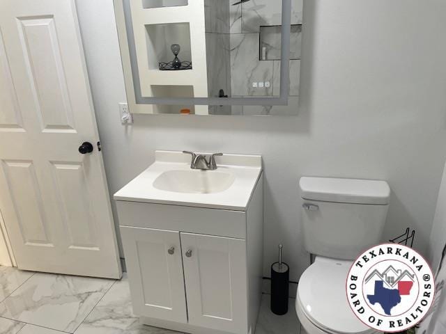 104 Pecan St, Atlanta, TX 75551 - bathroom with vanity, marble look tile flooring, and toilet