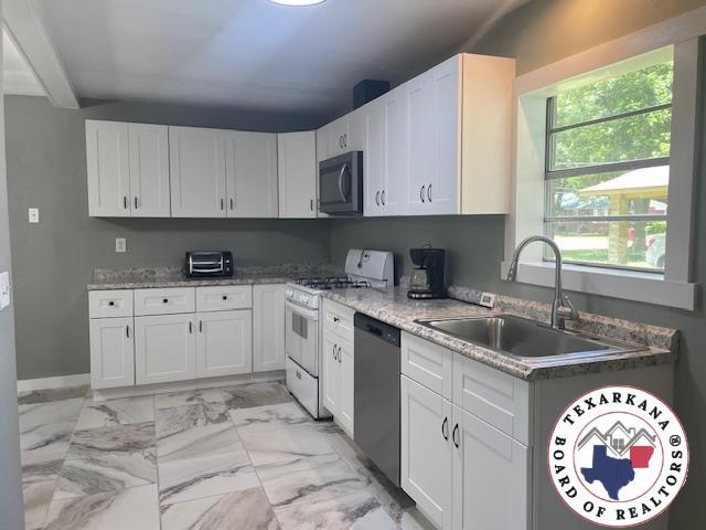 104 Pecan St, Atlanta, TX 75551 - kitchen with dishwasher, black microwave, white range with gas stovetop, a sink, and light marble finish flooring