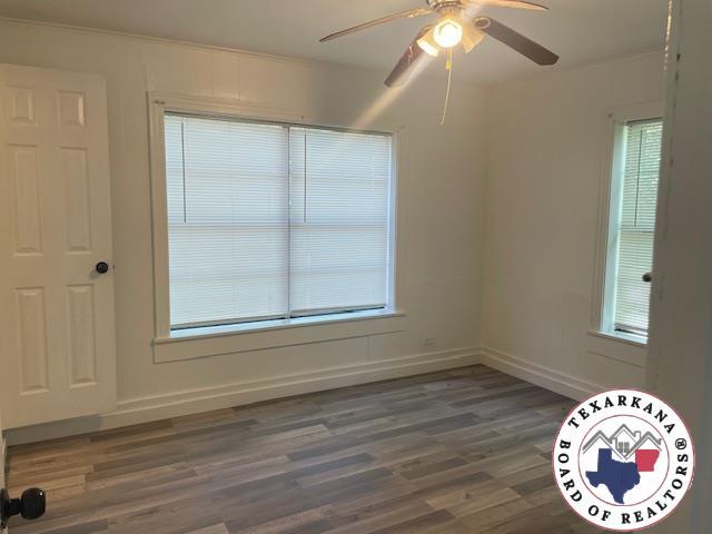 104 Pecan St, Atlanta, TX 75551 - spare room featuring a ceiling fan, wood finished floors, and baseboards