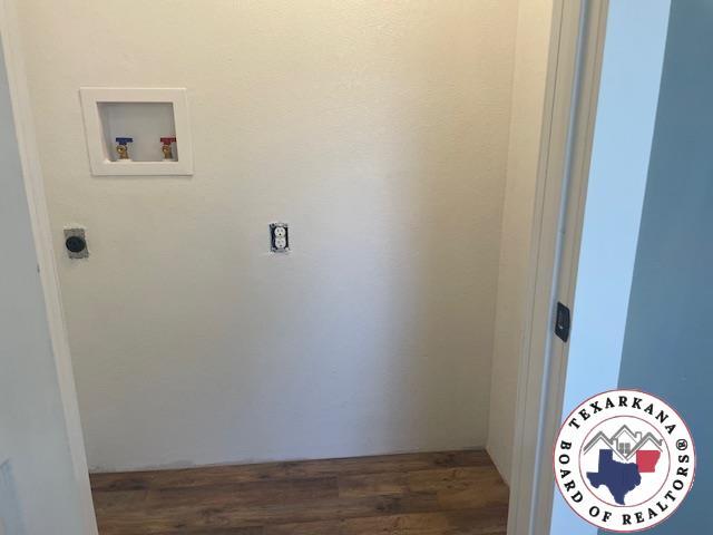 104 Pecan St, Atlanta, TX 75551 - washroom featuring hookup for a washing machine and wood finished floors