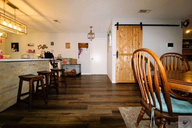 dining area featuring dark hardwood / wood-style floors and a barn door