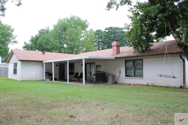 rear view of property featuring a patio area, a lawn, and cooling unit