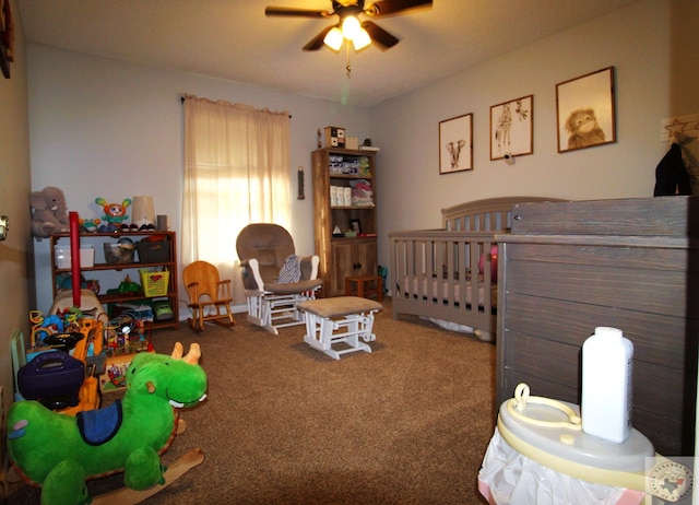 carpeted bedroom featuring ceiling fan and a nursery area