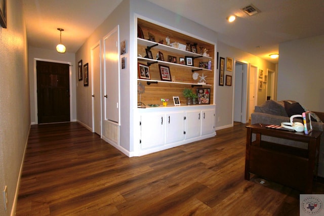 hallway with built in features and dark hardwood / wood-style flooring