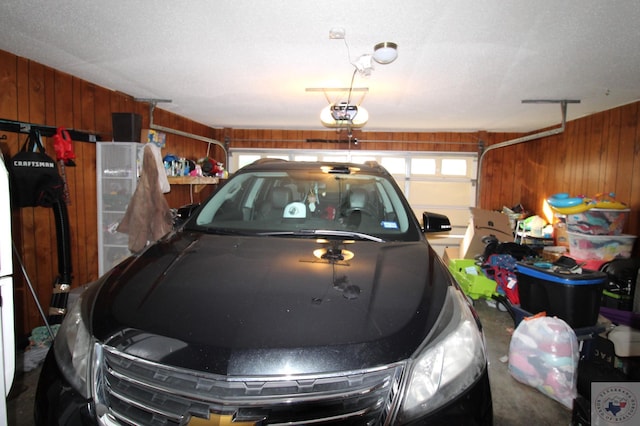 garage with a garage door opener and wood walls