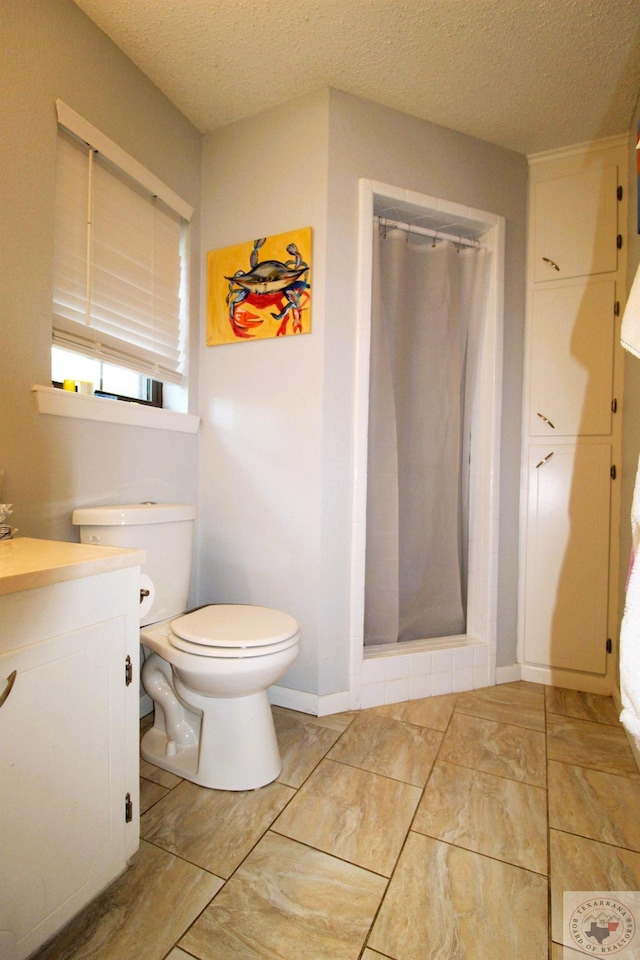 bathroom featuring a textured ceiling, toilet, vanity, and a shower with curtain