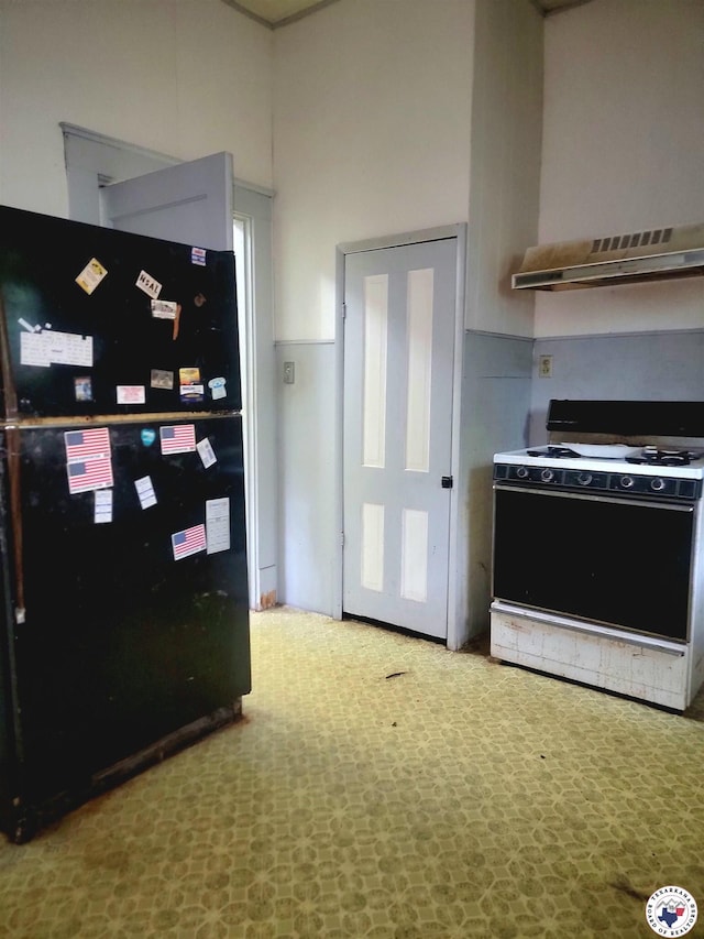 607 N Walnut St, Clarksville, TX 75426 - kitchen featuring white gas range, extractor fan, and wall chimney range hood