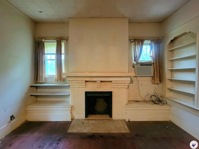 607 N Walnut St, Clarksville, TX 75426 - unfurnished living room featuring cooling unit, wood finished floors, and a brick fireplace