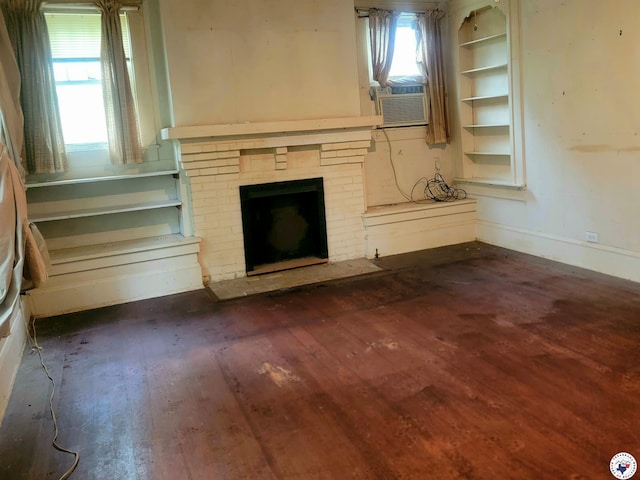 607 N Walnut St, Clarksville, TX 75426 - unfurnished living room featuring dark wood-style flooring, baseboards, a fireplace, and cooling unit
