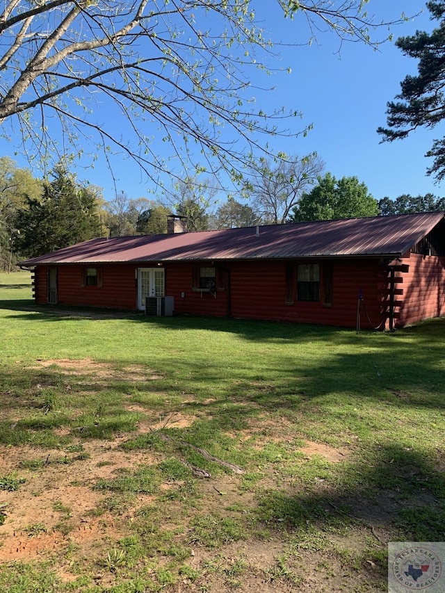 back of house with a lawn and central air condition unit