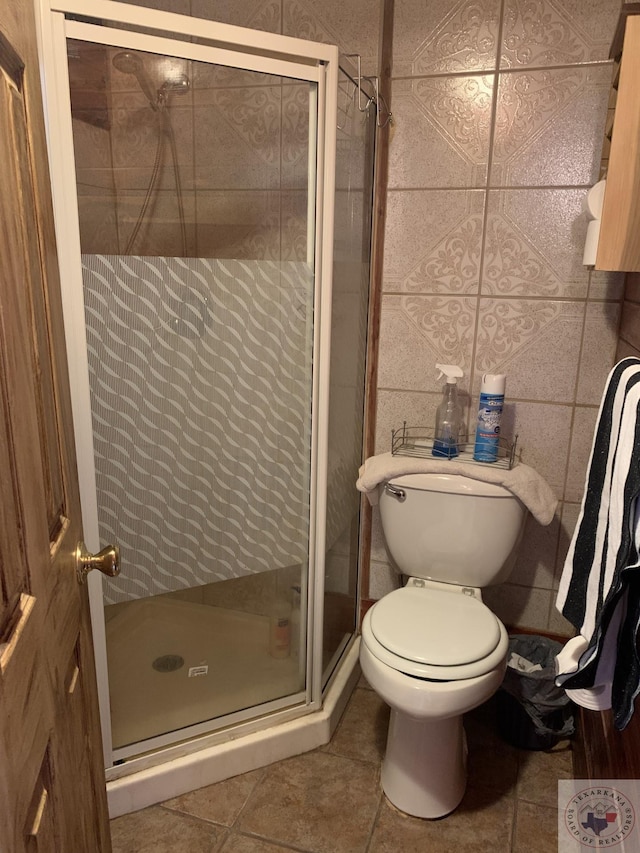 bathroom featuring tile walls, tile patterned floors, walk in shower, and toilet