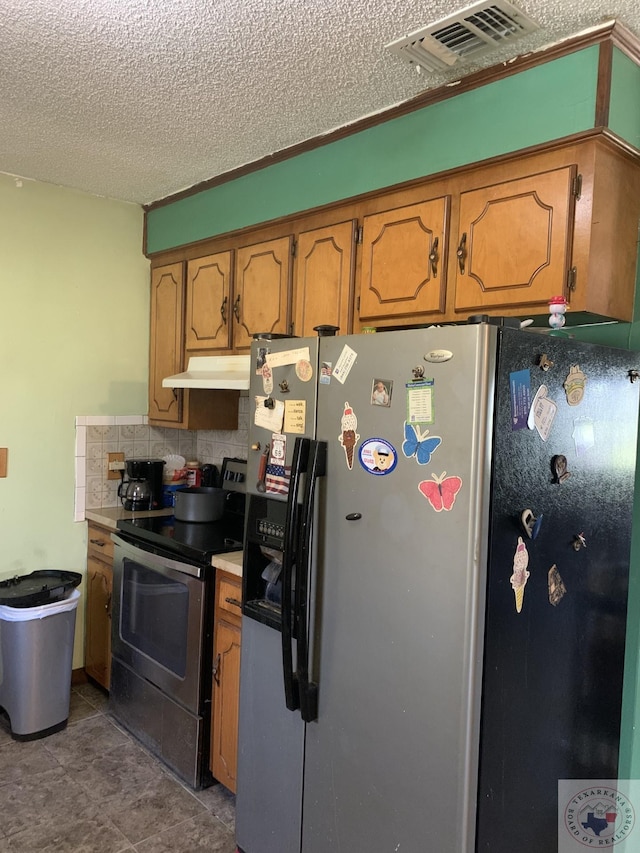 kitchen featuring a textured ceiling, tasteful backsplash, and stainless steel appliances