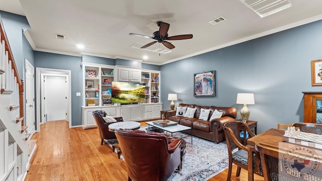 living room with crown molding, light wood-style flooring, visible vents, and a ceiling fan