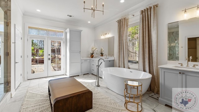 bathroom with crown molding, a freestanding bath, visible vents, and a wealth of natural light