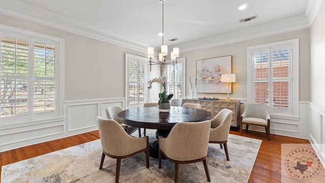 dining room featuring plenty of natural light, ornamental molding, and wood finished floors