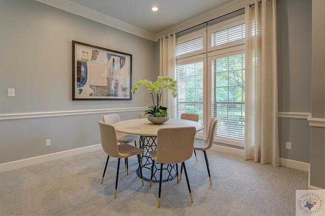 carpeted dining area with ornamental molding